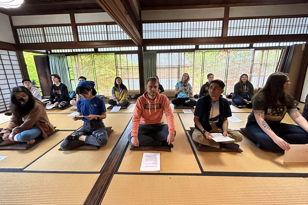 group of students sitting on yoga mats.