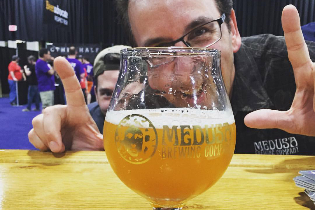 man posing with glass of beer.