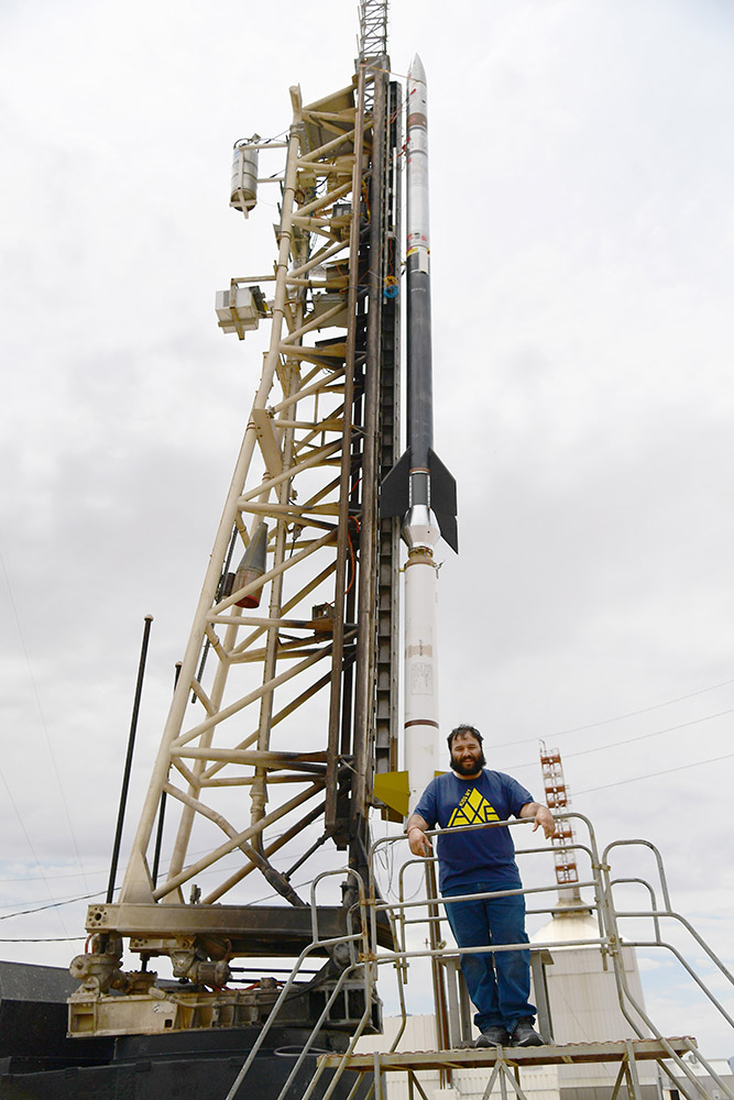 student standing next to a rocket at a missile range.