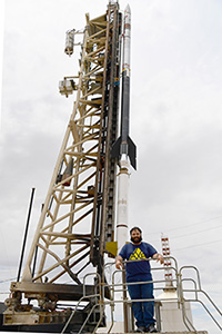 Mike Ortiz standing next to a rocket