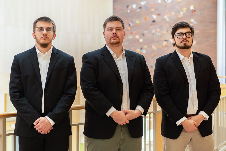 three students standing next to each other.