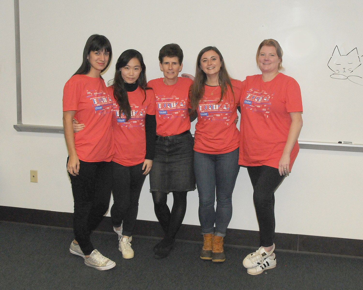 5 students with matching shirts pose together