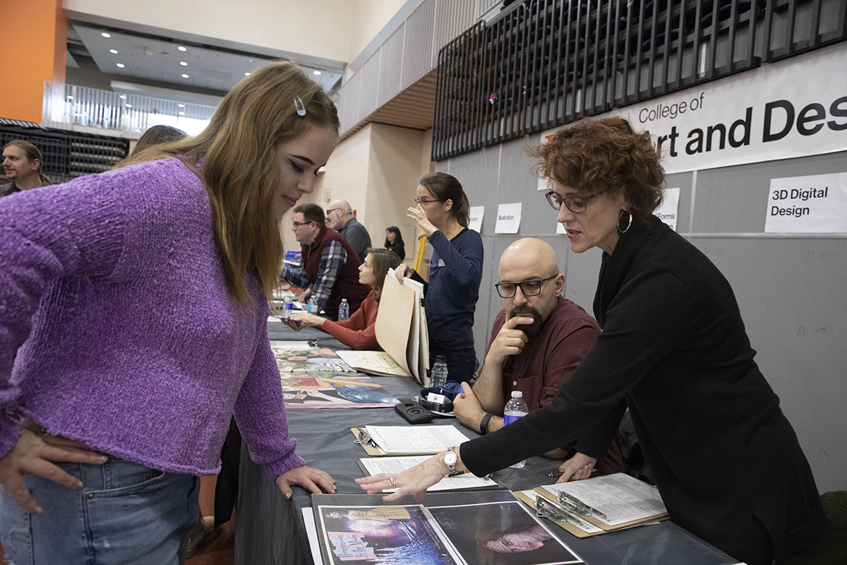 Faculty Keli DiRisio reviews a portfolio.