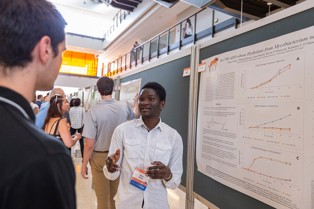 Student gives poster presentation.