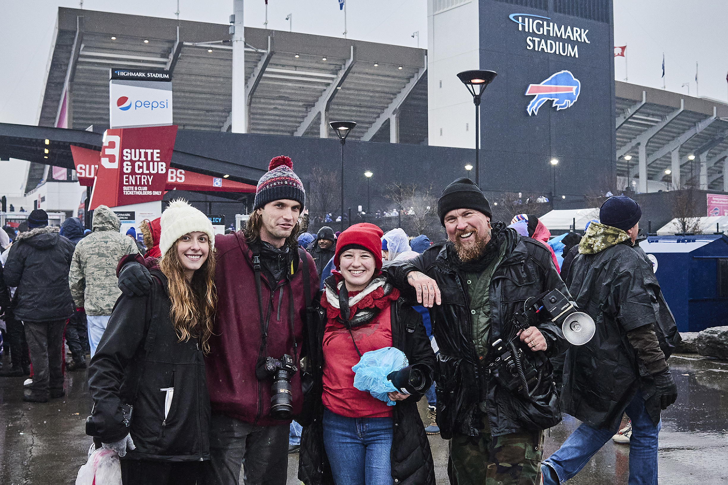 Four RIT photographers together, with their camera gear, outside the Bills' home stadium.