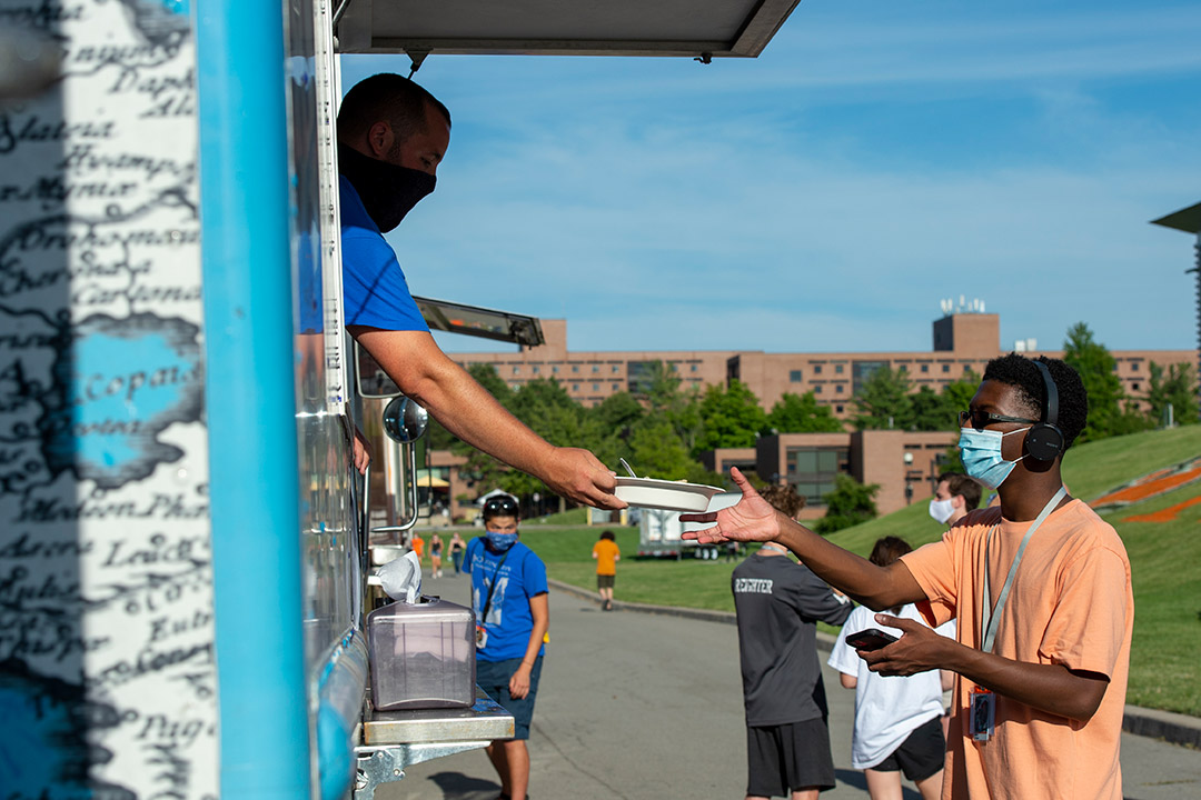 student receving a meal from a food truck.