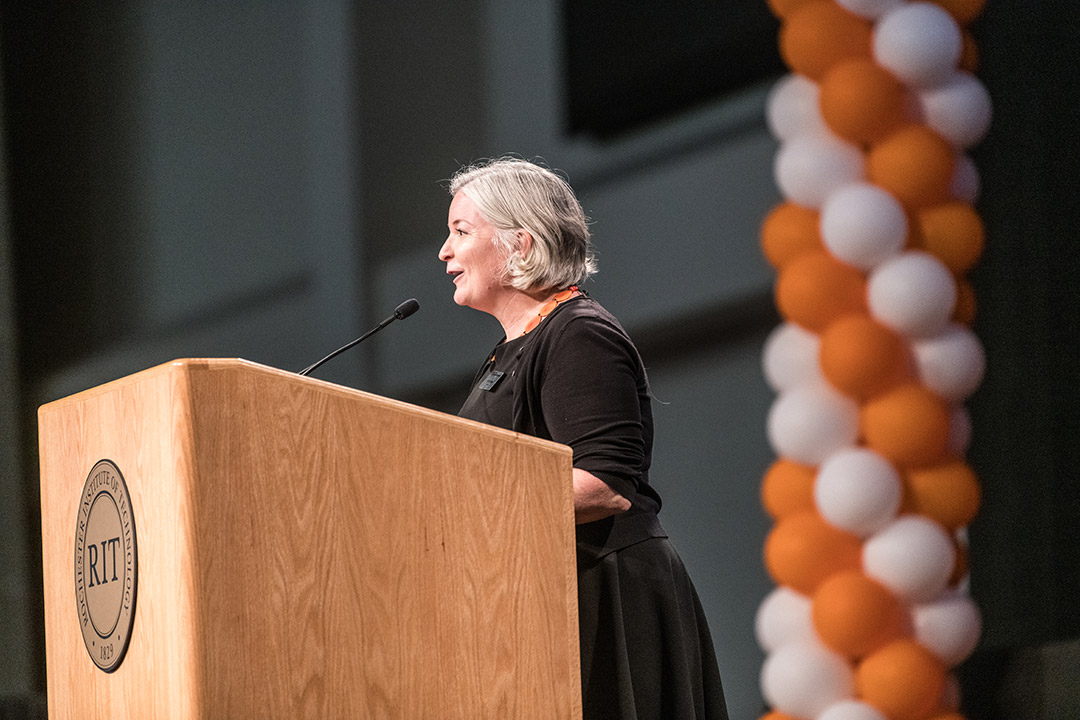 woman speaking at a podium.