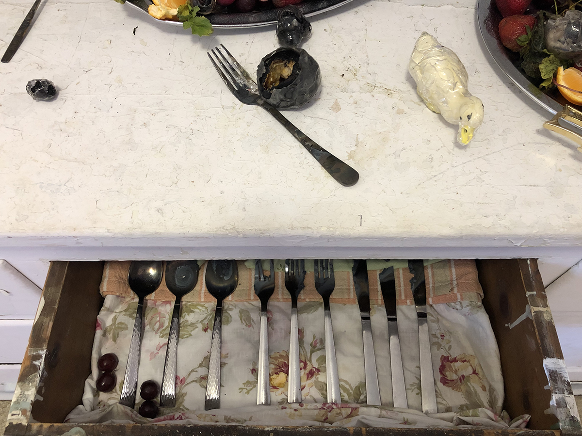 Glass silverware in a drawer and glass encased fruit on a counter. This piece was shown at a NYC art festival.