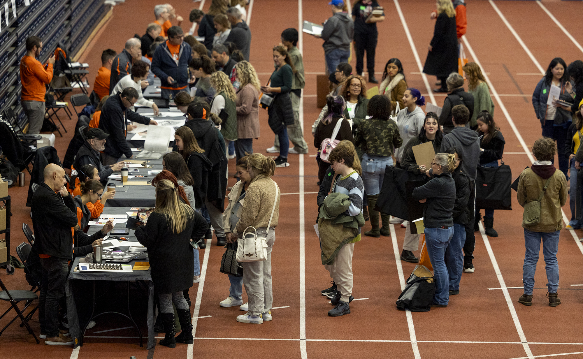 A group of students waits in line to have portfolios reviewed.