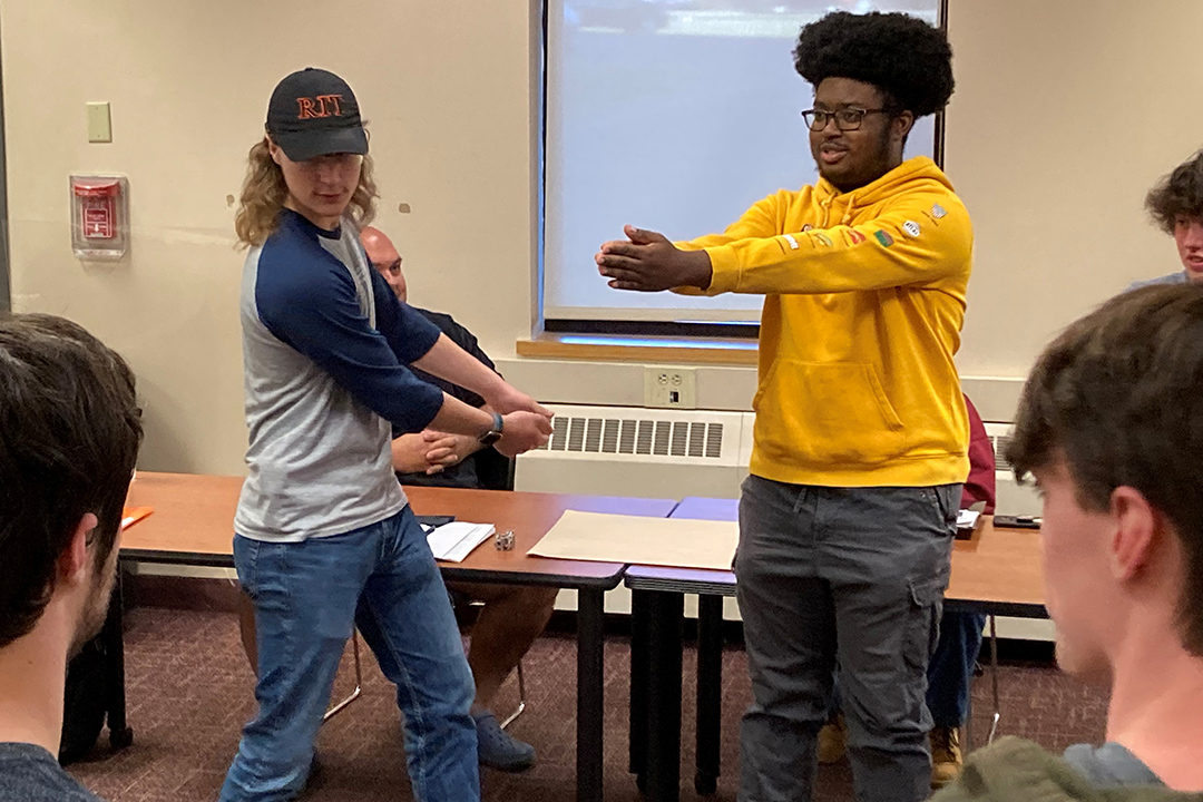 two students swinging their arms in an improv session.