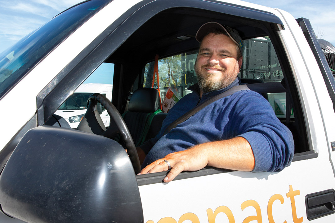 person sitting in driver's seat of pickup truck.