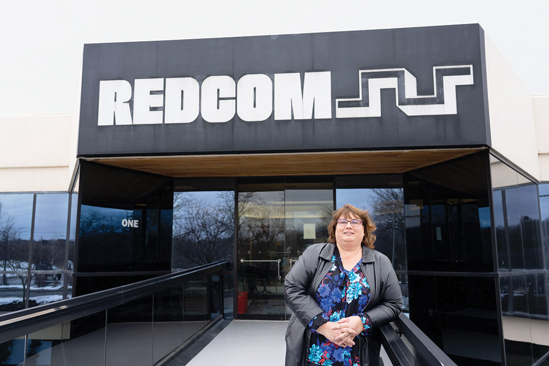 woman standing outside of the Redcom building.
