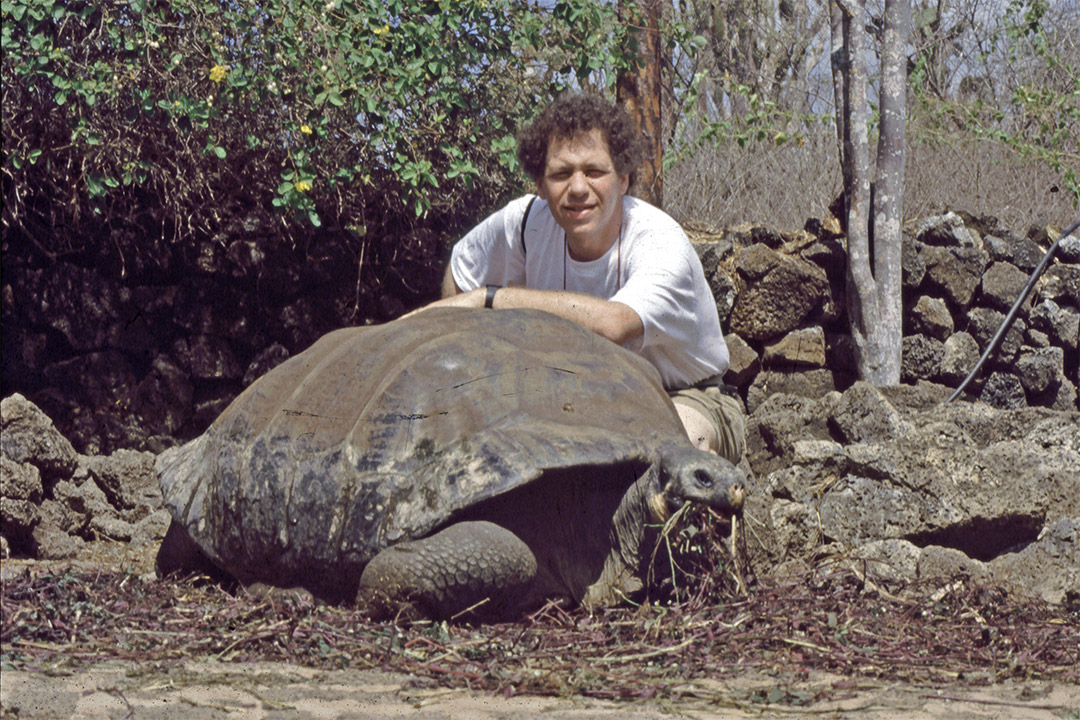 man posing with a giant tortoise in 1989.