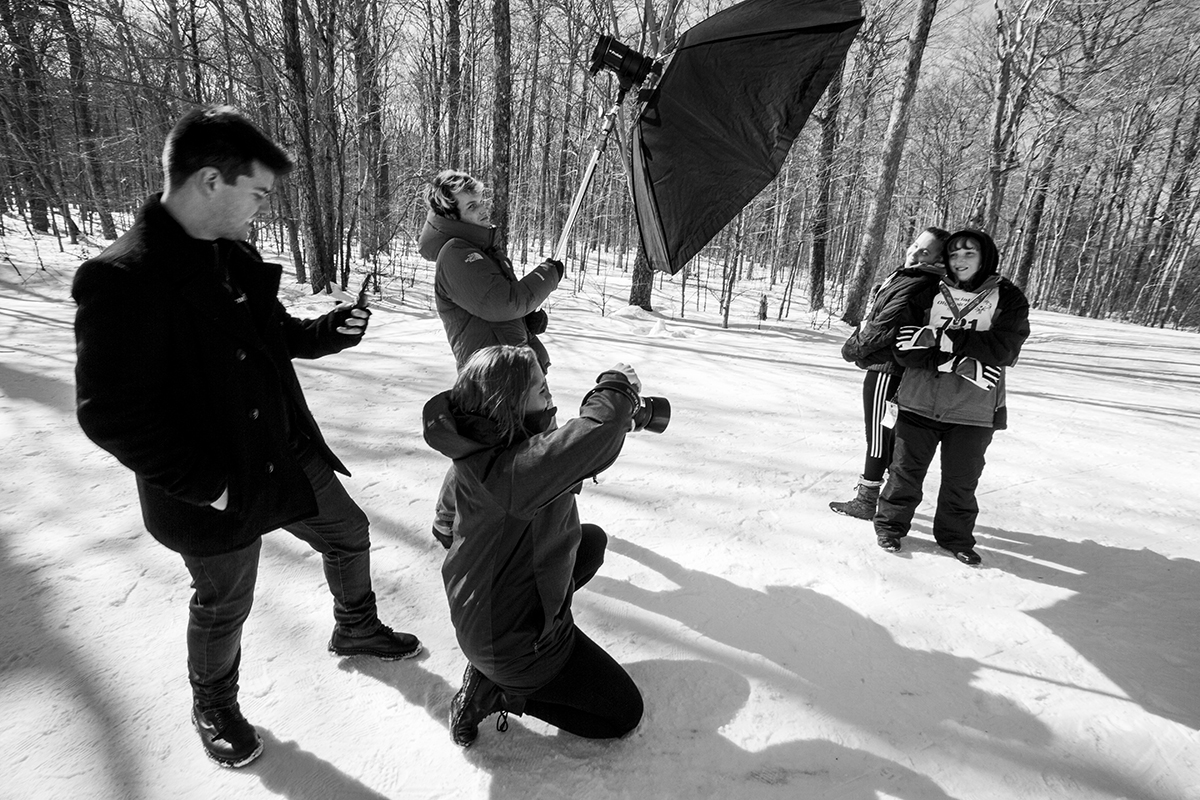 Students photograph athletes participating in the Special Olympics Winter Games.