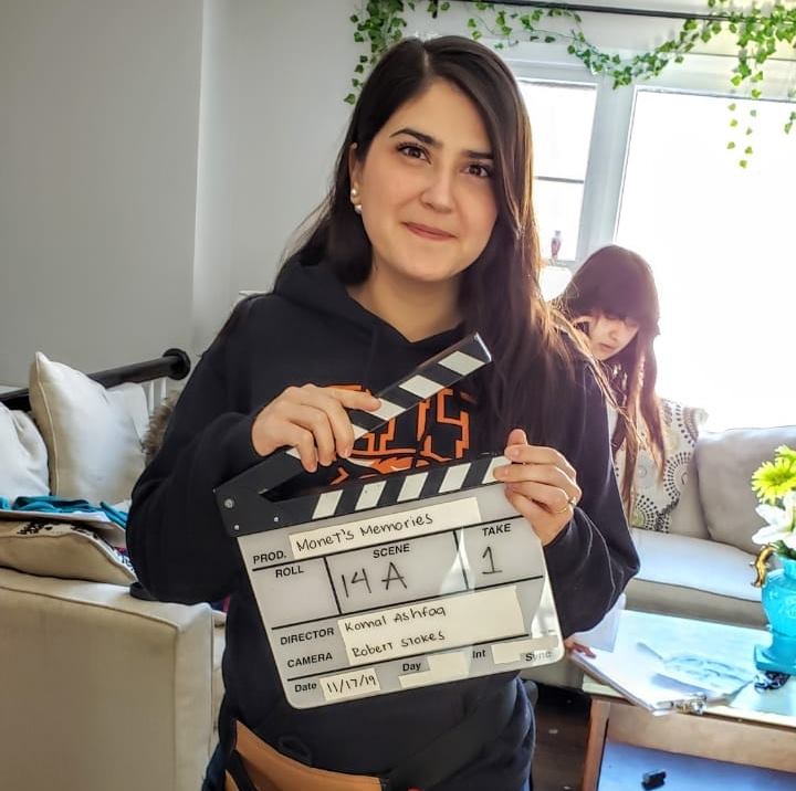 Selma Pena holding a clapperboard on a film set.