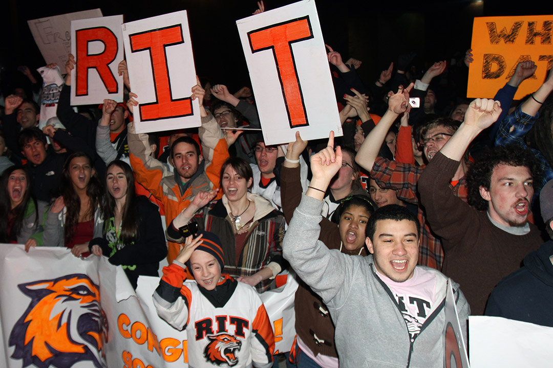 crowd holds sign with letters R. I. T.