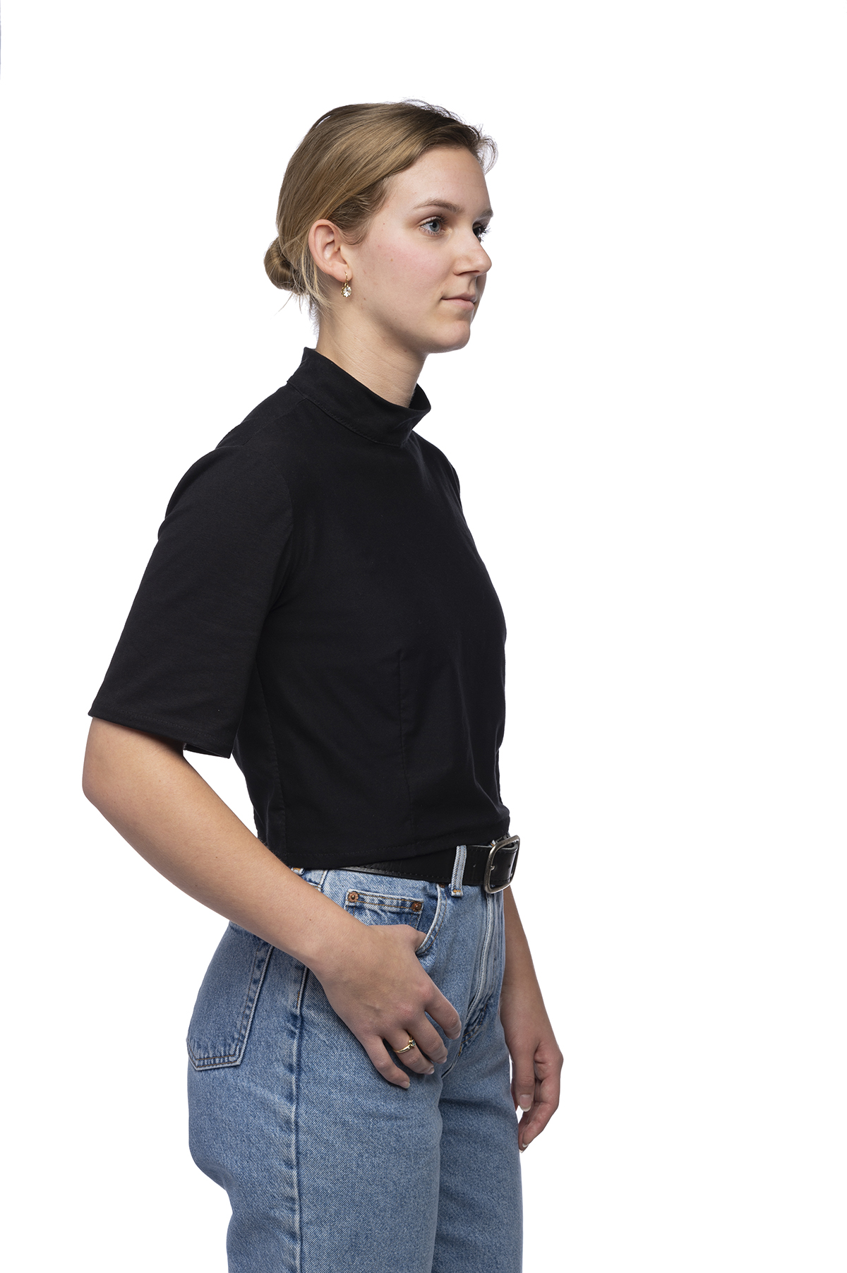 Functional clothing design of a black top tucked into denim jeans.