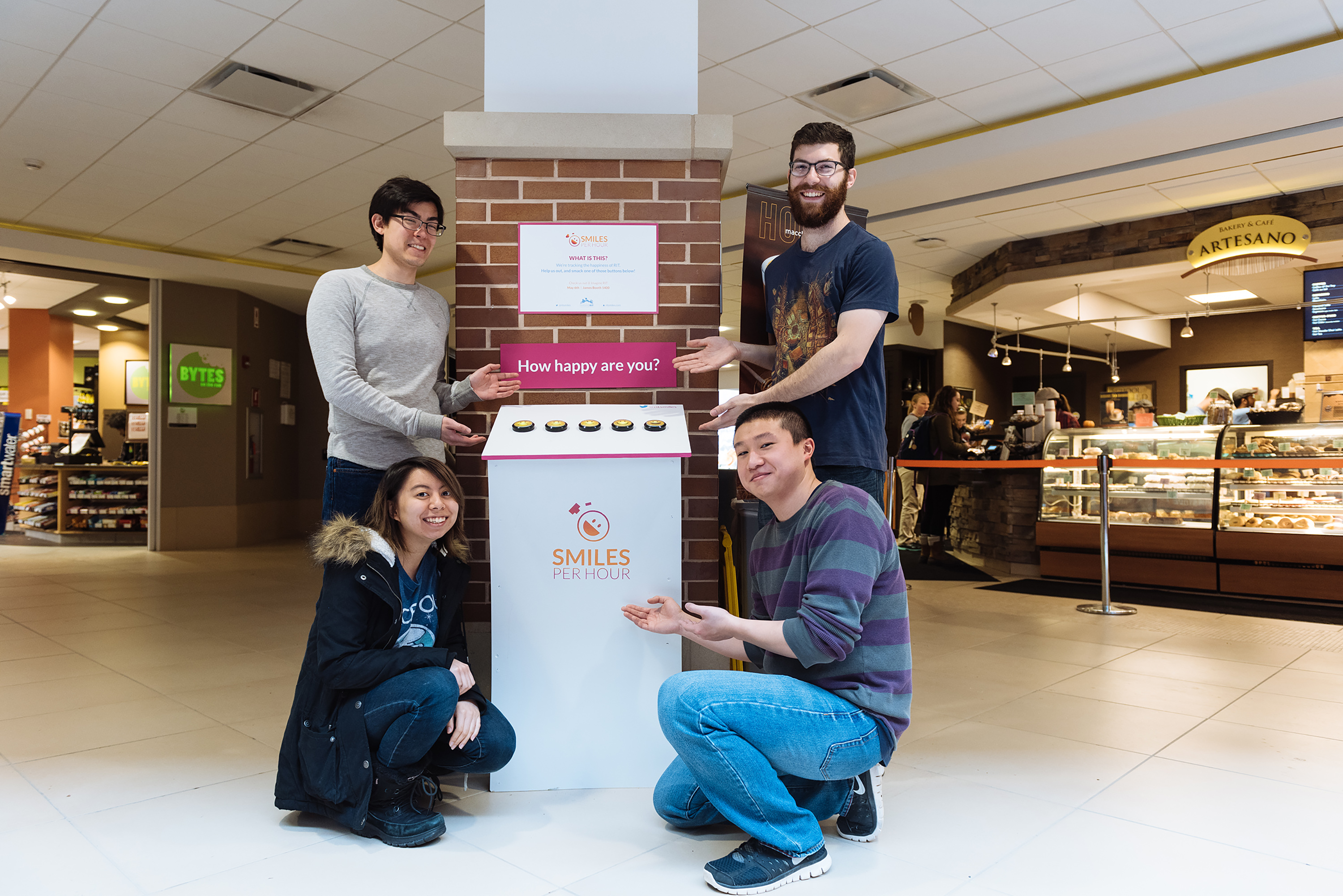 4 people pose next to a white podium in front of Artesanos