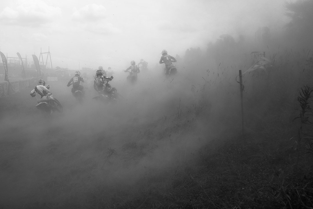 cloud of dust around dirt bike riders.