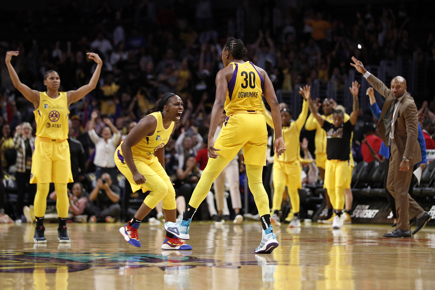 Players on the LA Sparks WNBA team celebrate during a game.