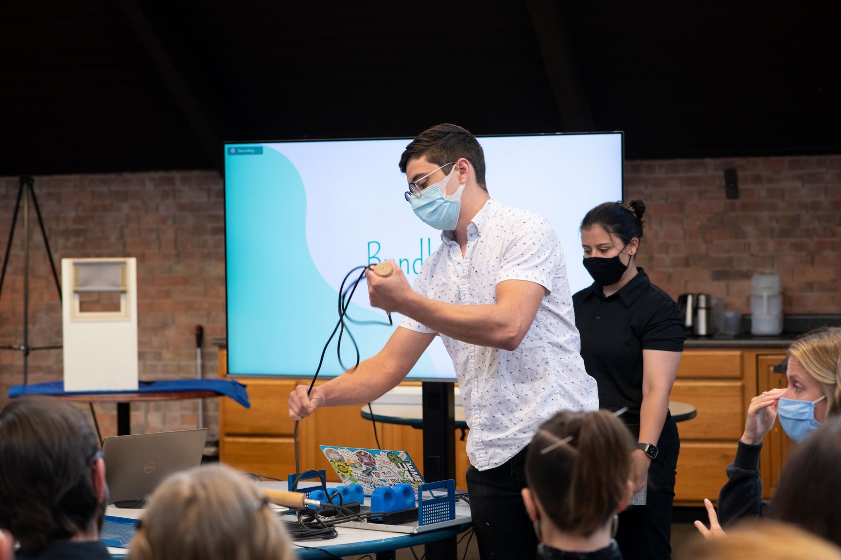 A person in a mask pulls wires from a device