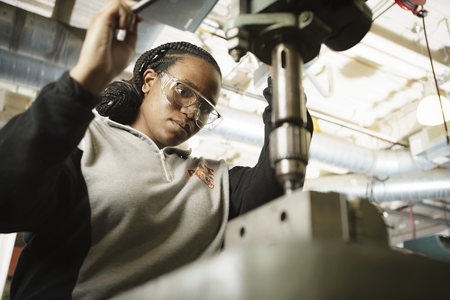 RIT student, Symonne Francis operating a drill press in the Machine Shop