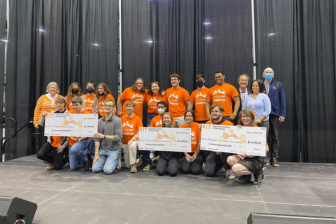 group of students posing with giant novelty checks.