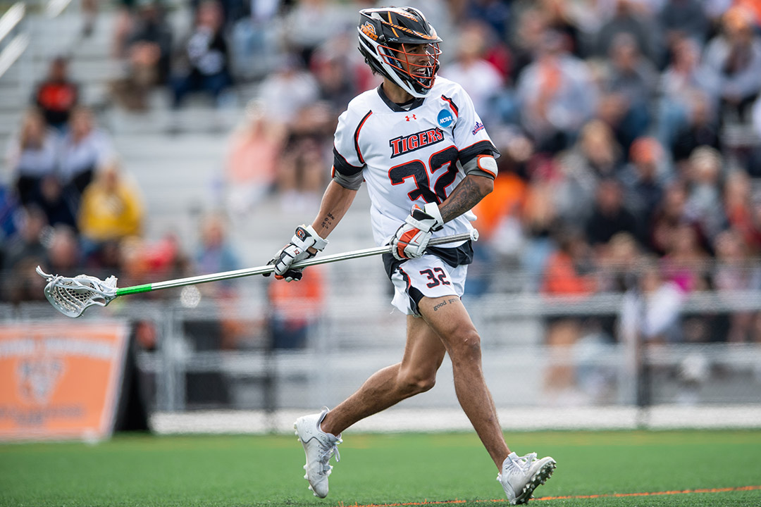 college lacrosse player running with his stick.