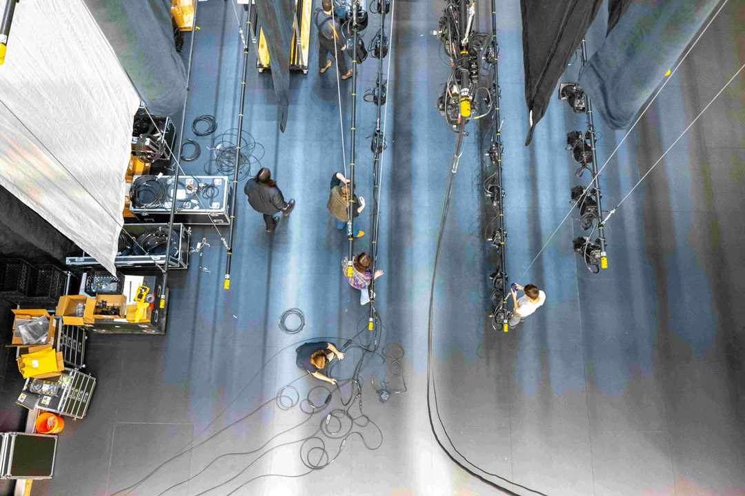 An aerial view shows people working backstage in a theater.