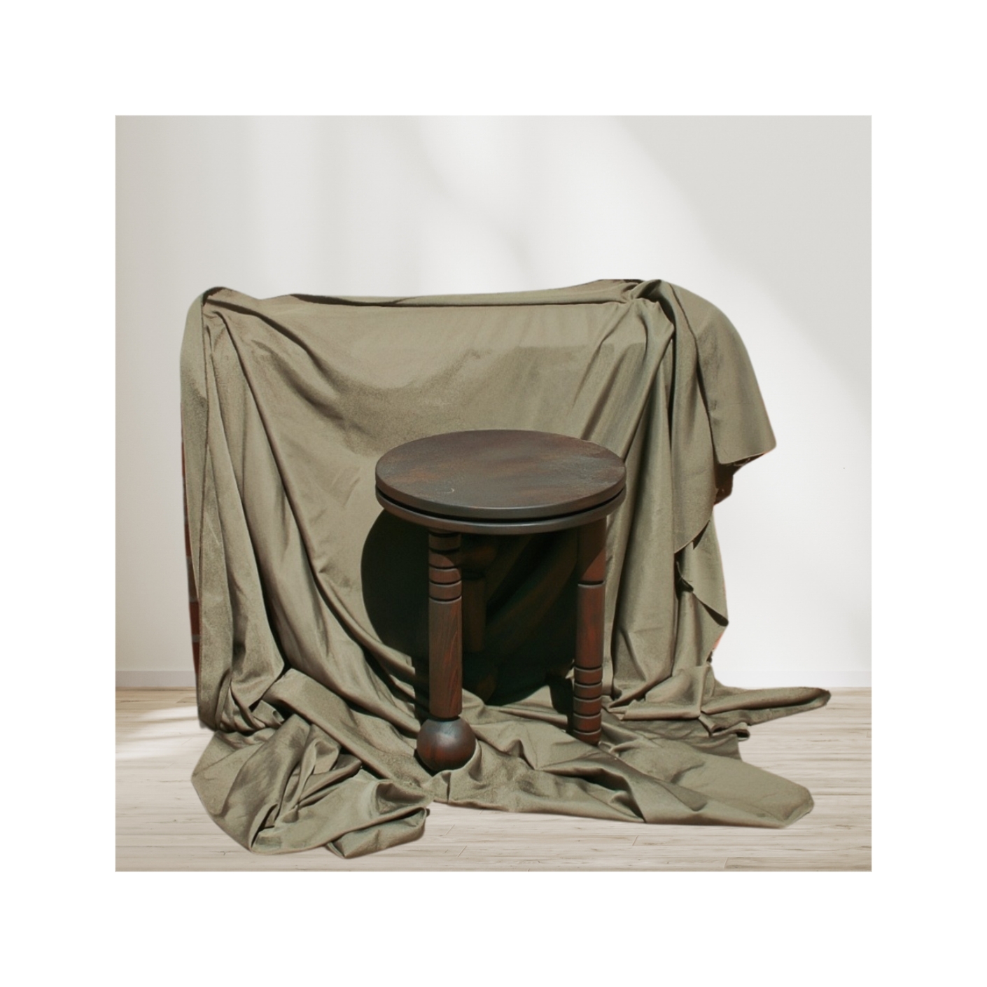A stool made by Tobi Ashiru set against a drape.