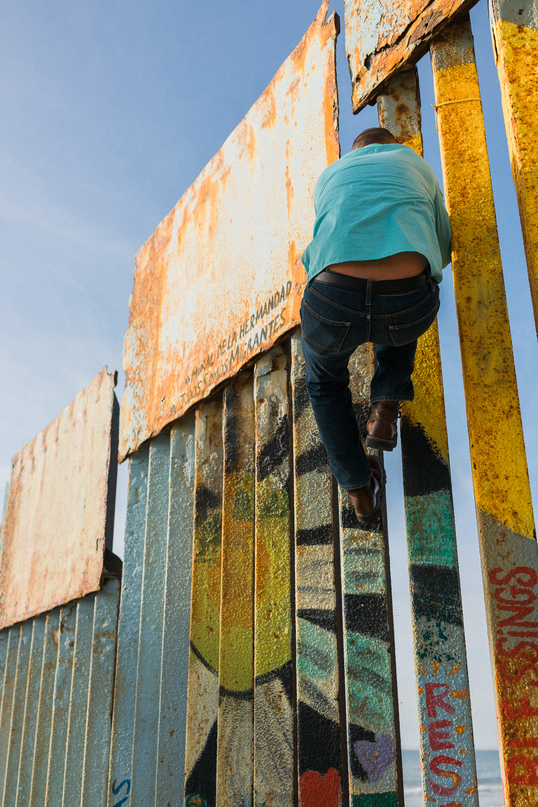 A man climbs a structure covered with art.