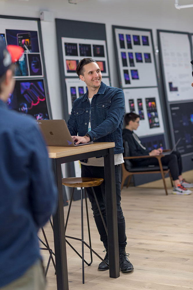 person standing at a table working on a laptop.