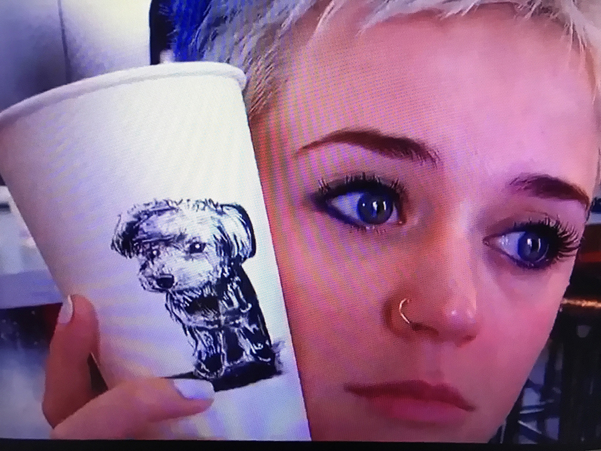 Katy Perry holds coffee cup art done by alumna Ilana Schwartz.