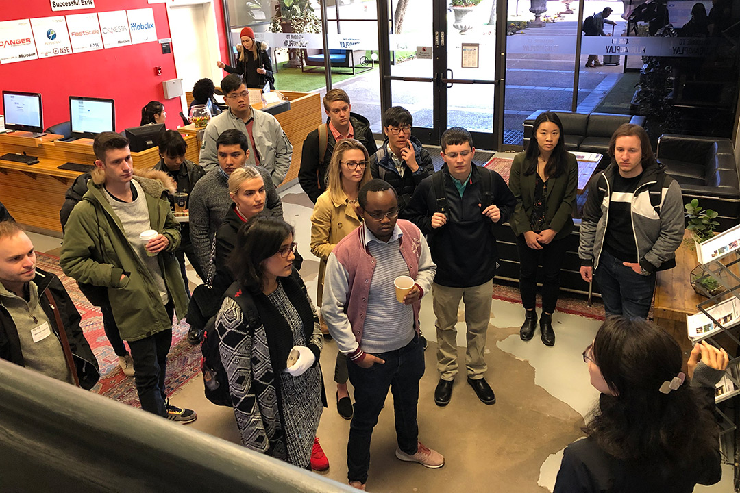 Group of students stands in business lobby