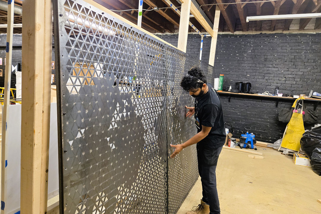 Randy Fernando stages pieces of an art installation at a studio. 