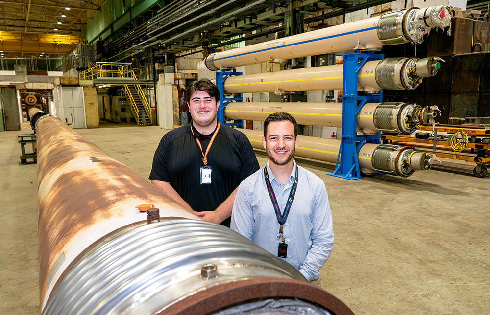 RIT alumnus Jonathon Greene, right, and Desjardins are pictured in front of the new four-tier magnet storage stand Desjardins designed. 