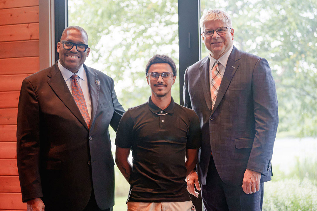 : Incoming Rochester City Scholar Carlos Gaston Lopez, center, is introduced by Vice President and Associate Provost for Access, Engagement, and Success Keith Jenkins, left, and R I T President Bill Sanders, right.