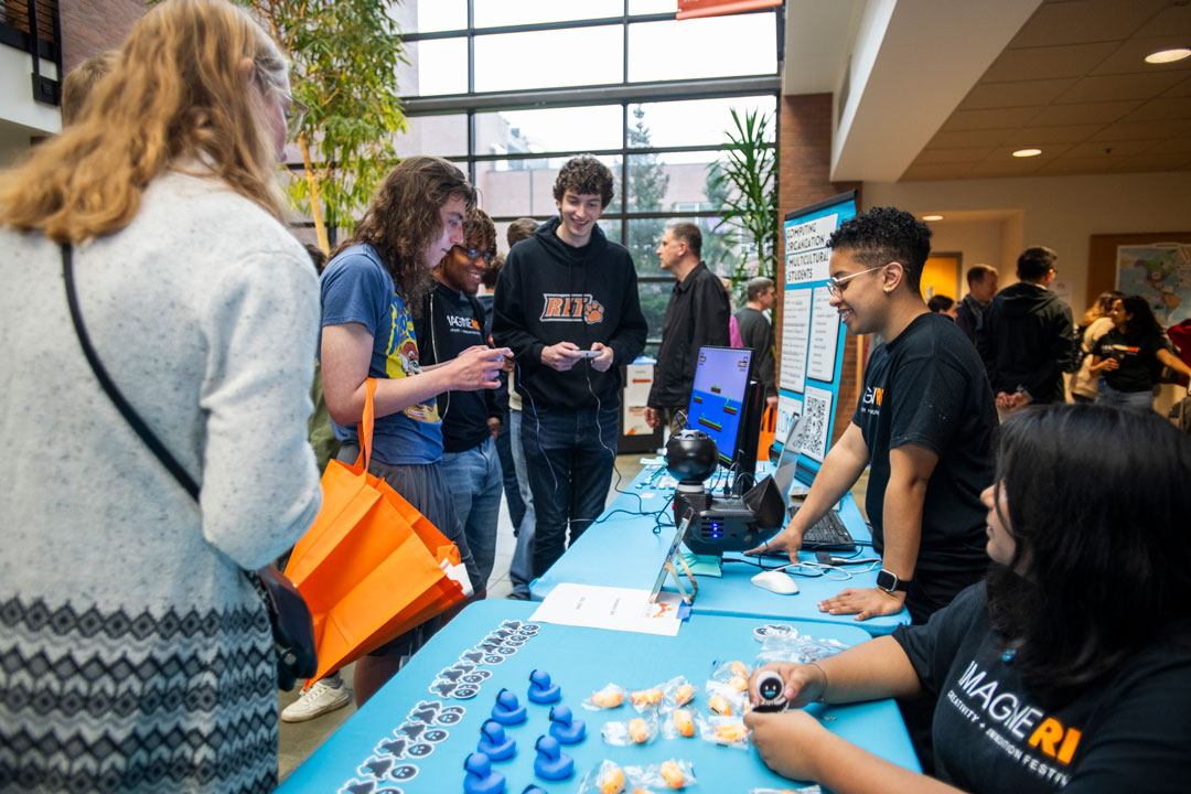 Gaming students from RIT’s Golisano College of Computing and Information Sciences show Quackbox 360 to visitors 