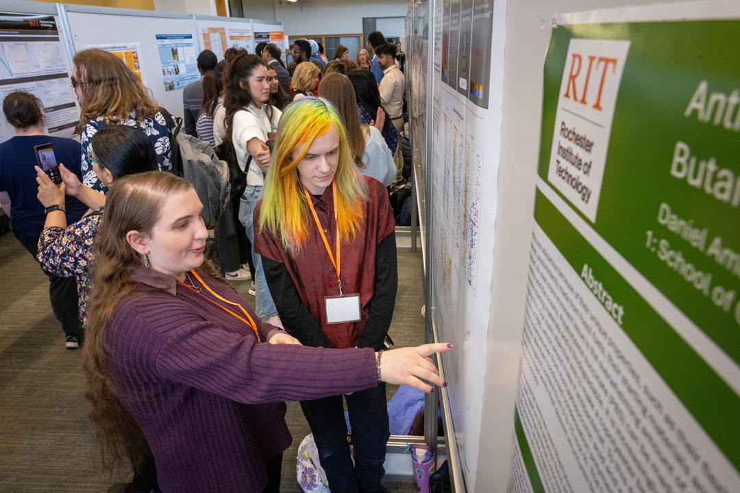 Gwynneth Buckton, left, practice designing and presenting a research poster. Here, she talks to Daniel Amburgey, a fellow presenter and materials science and engineering MS student.