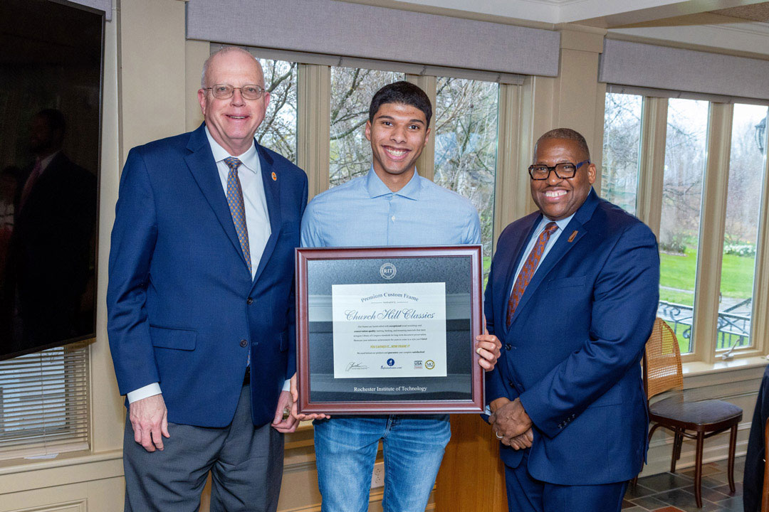 Joseph Vazquez, center, celebrated his graduation at a reception for Rochester City Scholars at RIT’s Liberty Hill in 2025. With him are former RIT President David Munson, left, and Vice President and Associate Provost for Access, Engagement, and Success Keith Jenkins, right. 