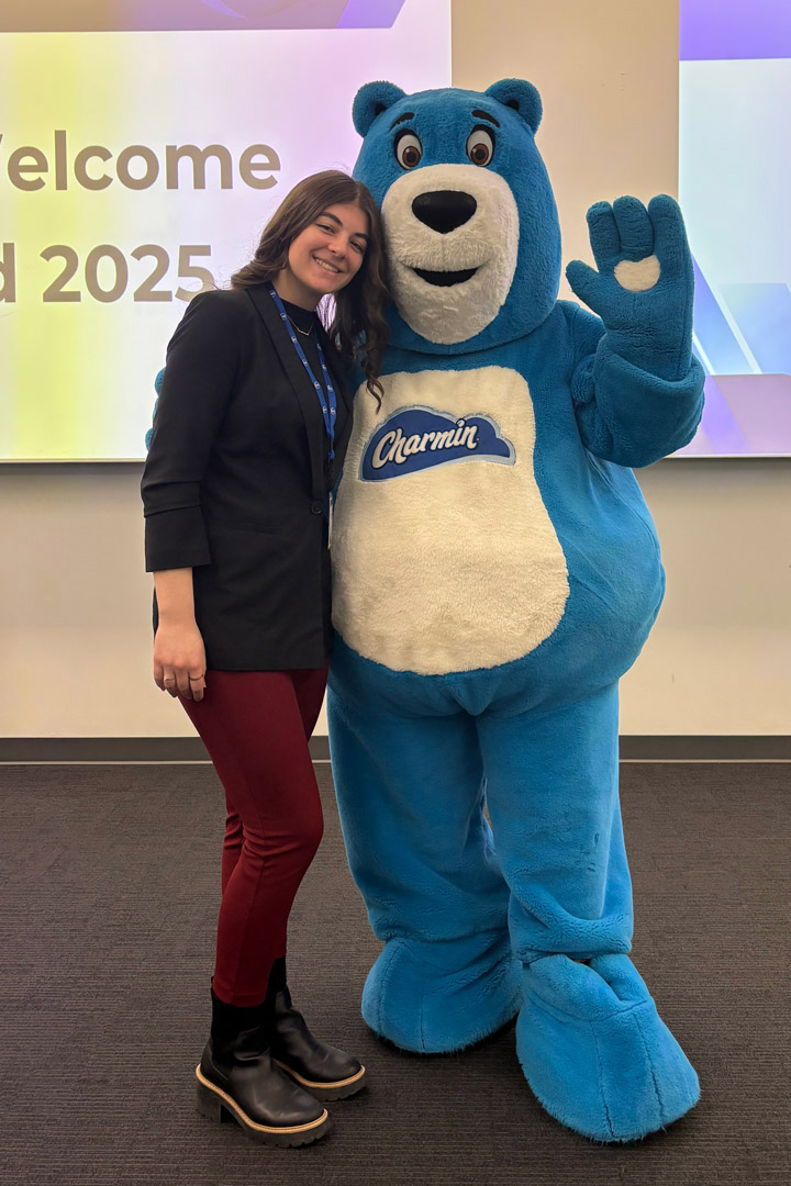 a college age girl stands next to the mascot for charmin toilet paper