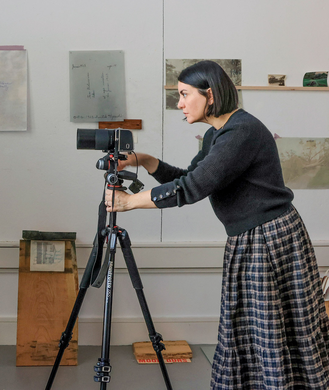 Toni Pepe is shown in profile, setting up a camera in an art gallery.