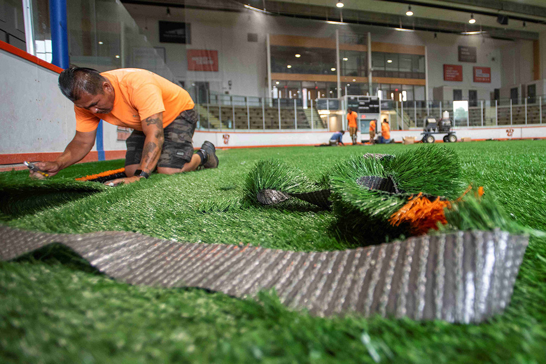 turf flooring is installed on an indoor field.