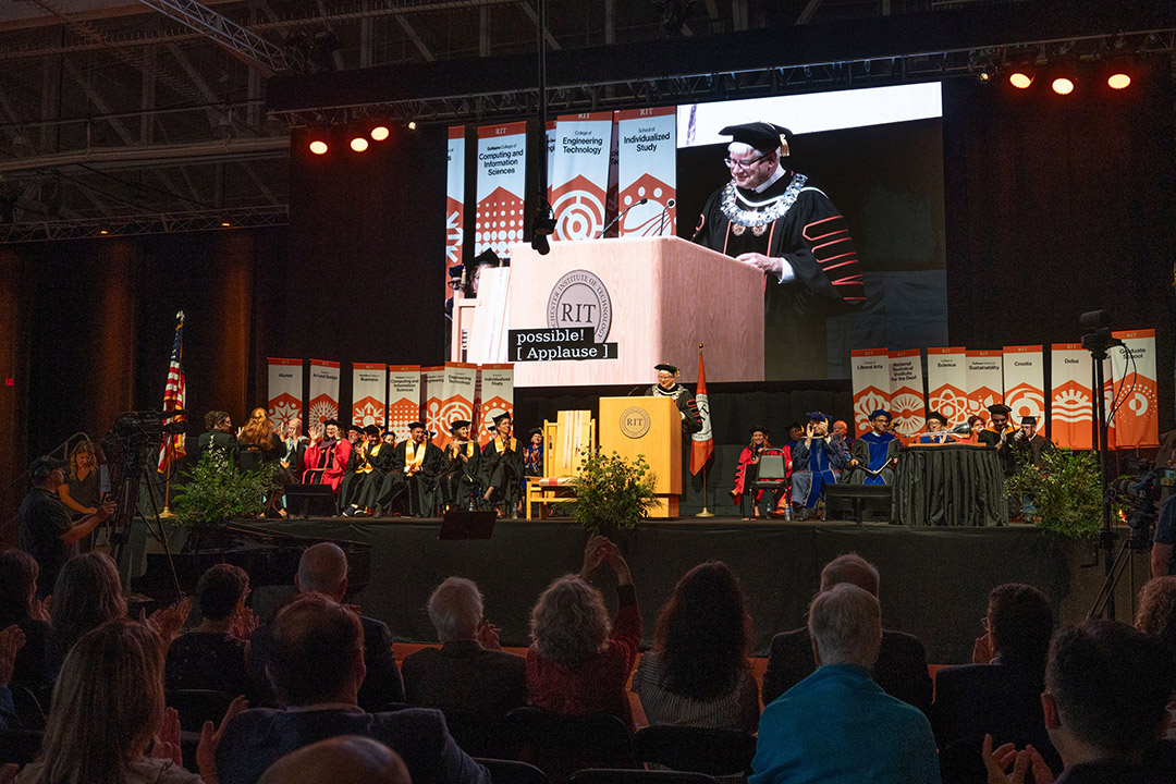 Bill Sanders delivers remarks at the ceremony from behind an R I T podium