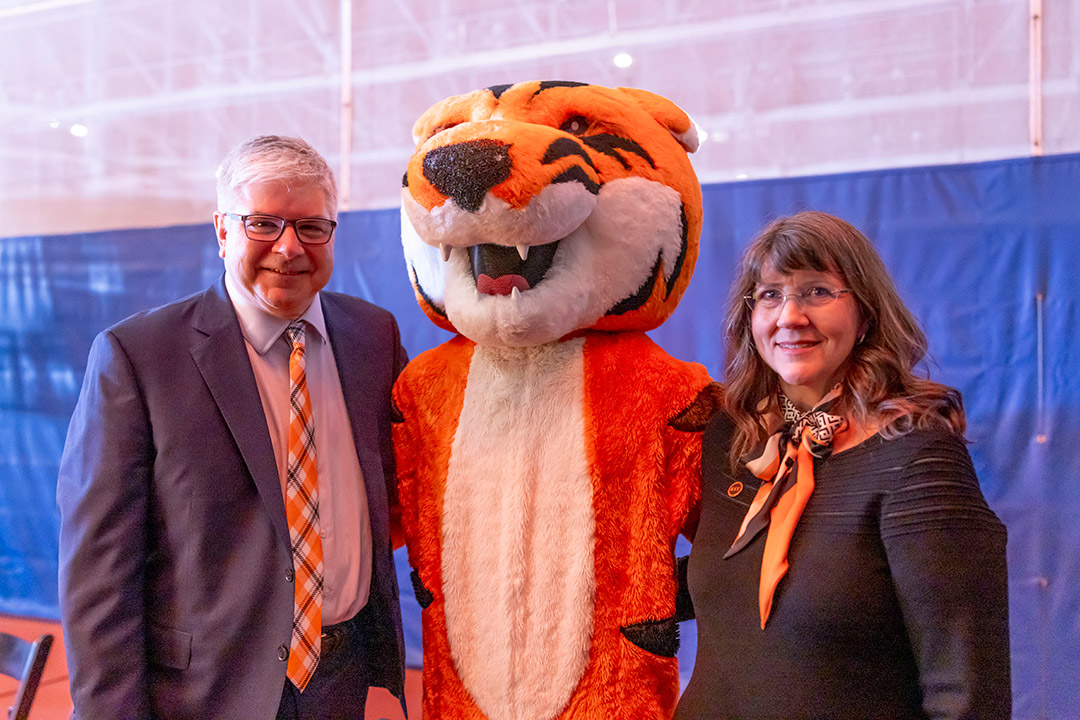 William Saunders and his wife Emily flank the RIT mascot, RITchie.