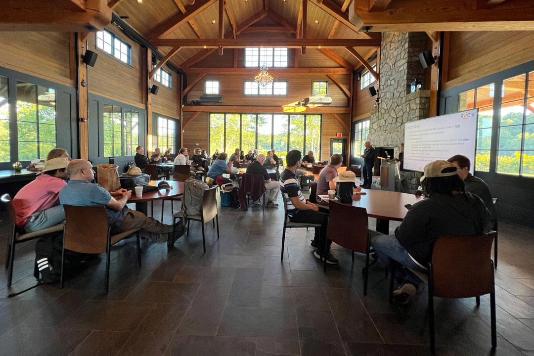 Researchers from around the world gather inside the lodge at RIT’s Tait Preserve for a morning briefing during ROCX 2025