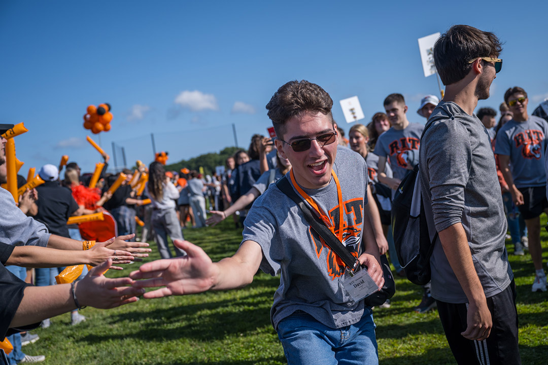 a student gives a high-five to a bystander during the Tiger Walk.