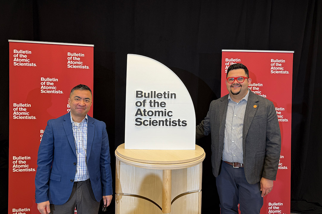 From left, Tom Weis and Juan Noguera pose next to the back of the redesigned Doomsday Clock, which was unveiled on Jan. 28 in Washington, D.C.