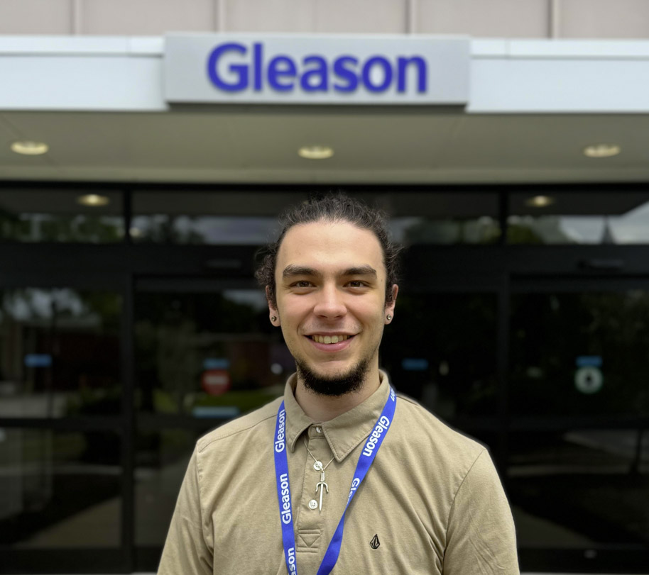 a man stands in front of a building with a sign that reads Gleason
