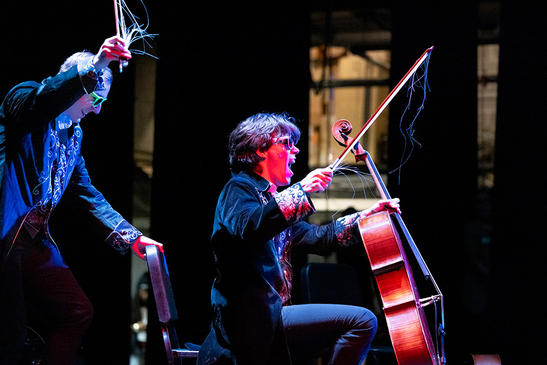 two students play instrument in sunglasses on a stage